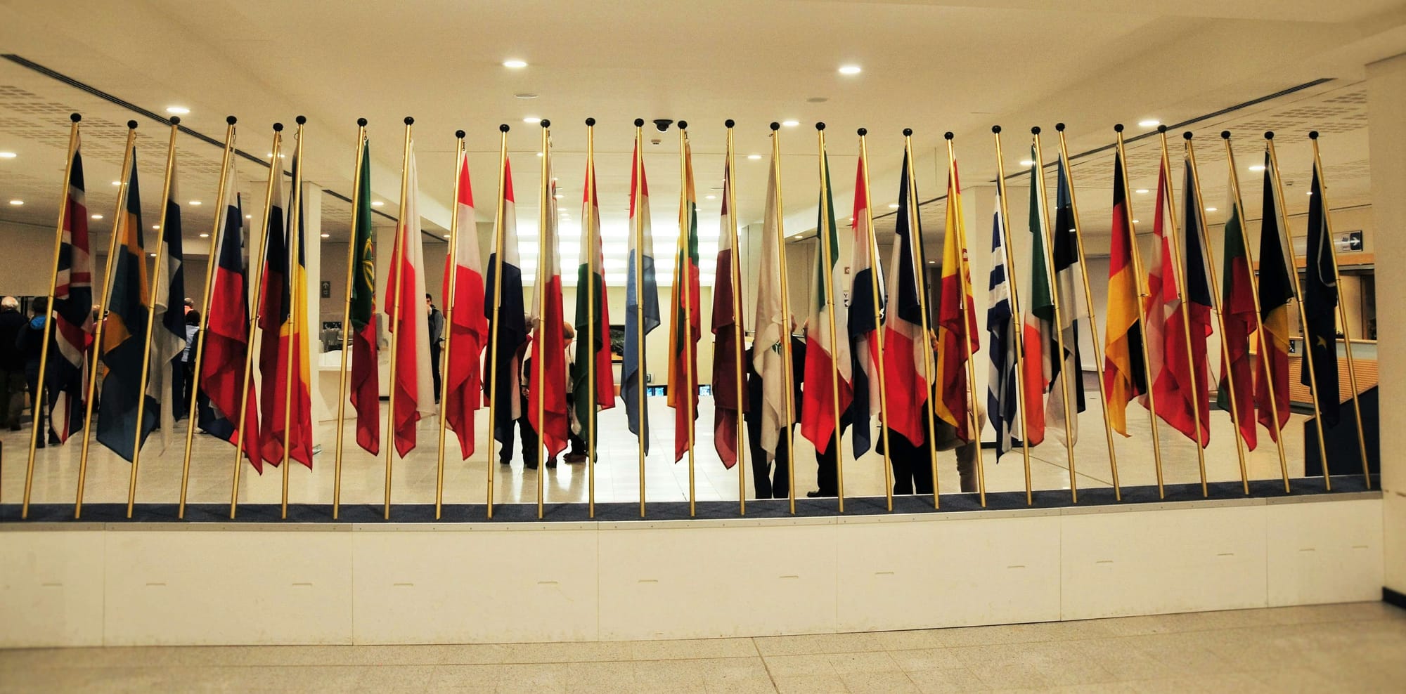 Reihe internationaler Flaggen in einem modernen Innenraum – Symbol für globale Vielfalt, Diplomatie und internationale Zusammenarbeit in einer offiziellen Umgebung.